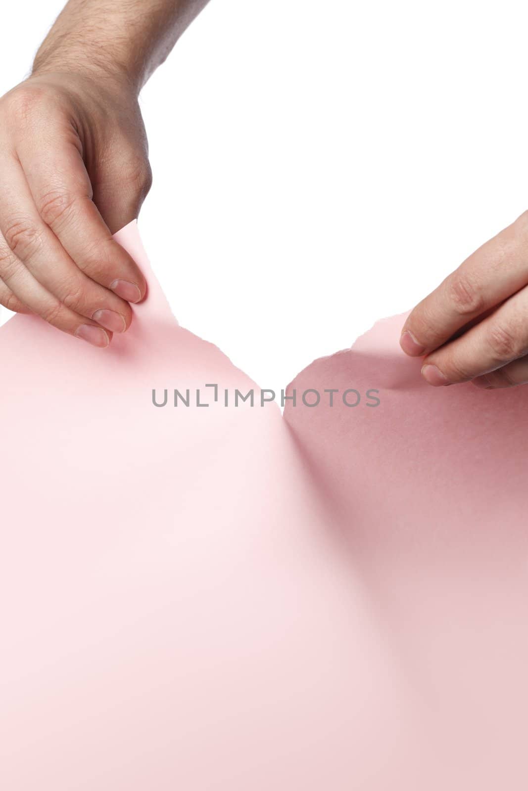 Man tearing pink paper with his hands.