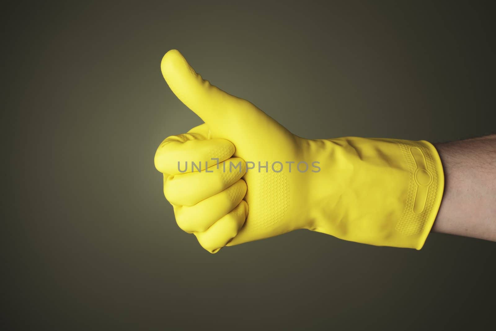 A hand wearing a yellow protective rubber glove does "thumb up" gesture