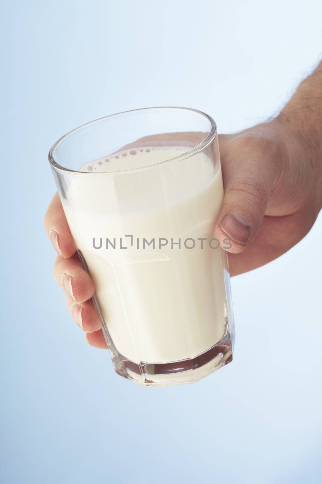 A Hand holding a glass of milk