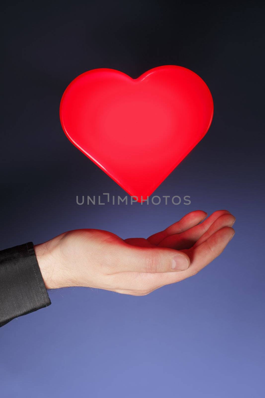 A glowing heart shape hovering above a hand