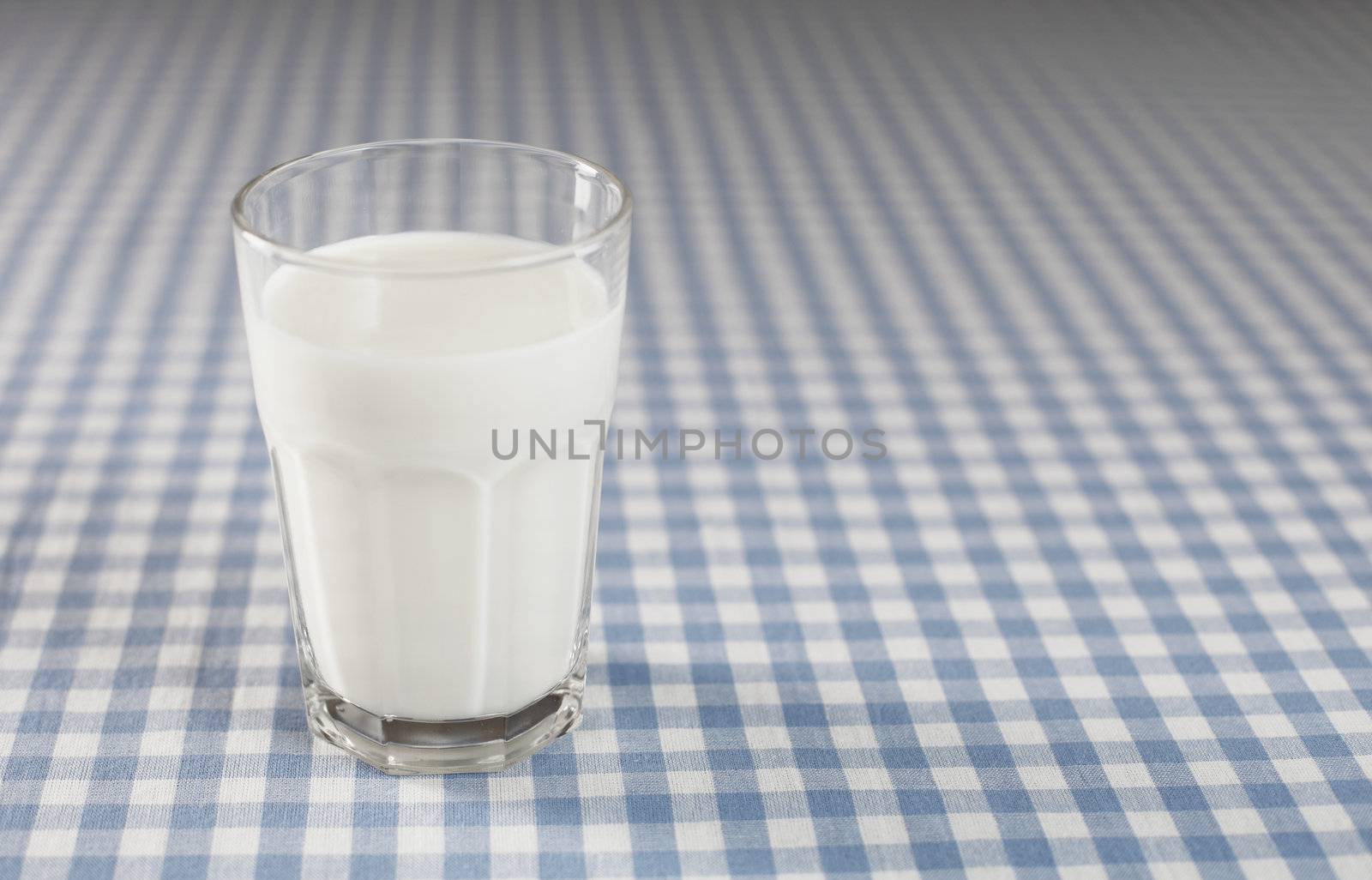 A Glass of milk on plaid tablecloth