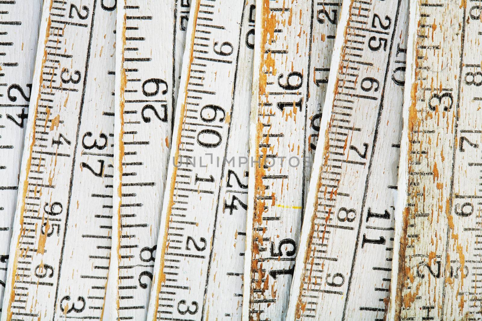 Old and worn white folding carpenters ruler in closeup