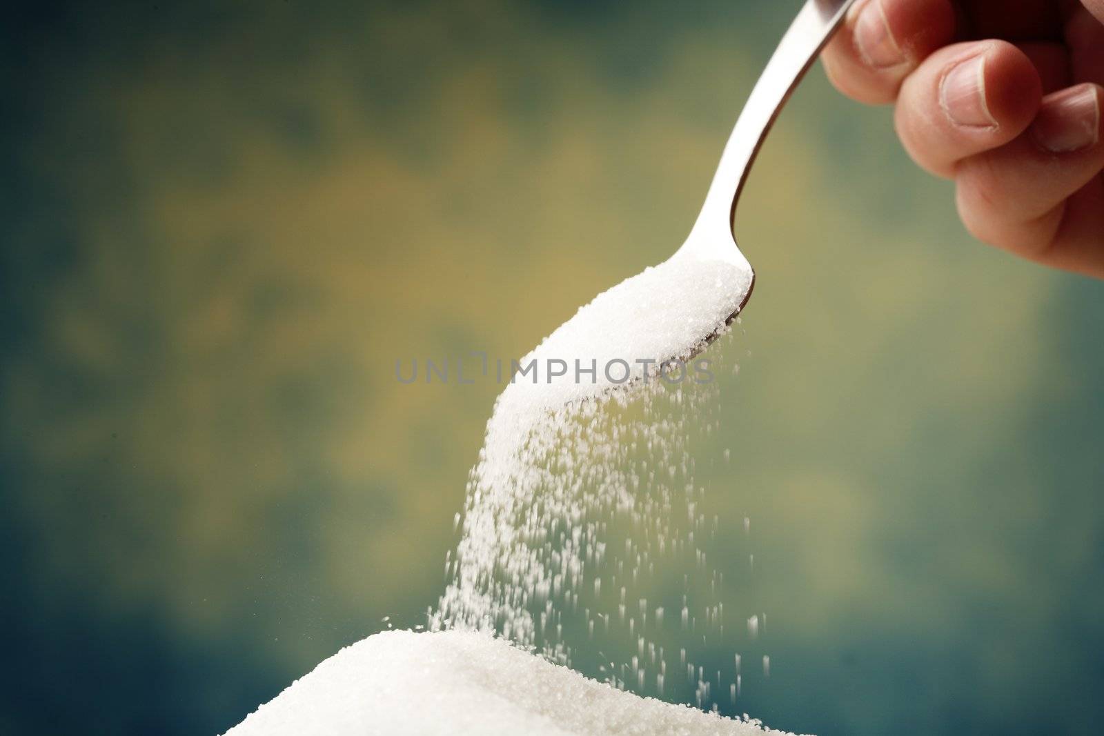 Adding sugar with a spoon.