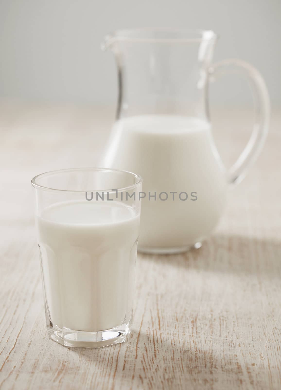 A Glass of milk. Milk jug in the background.