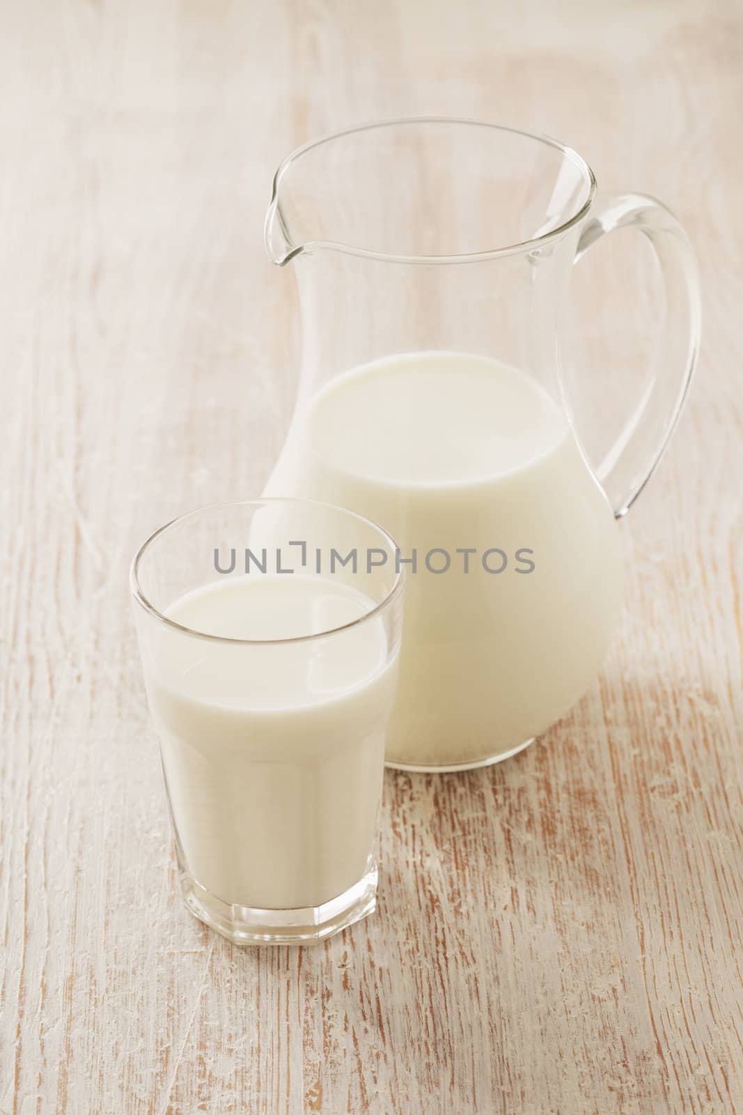 A Glass and a pitcher with milk