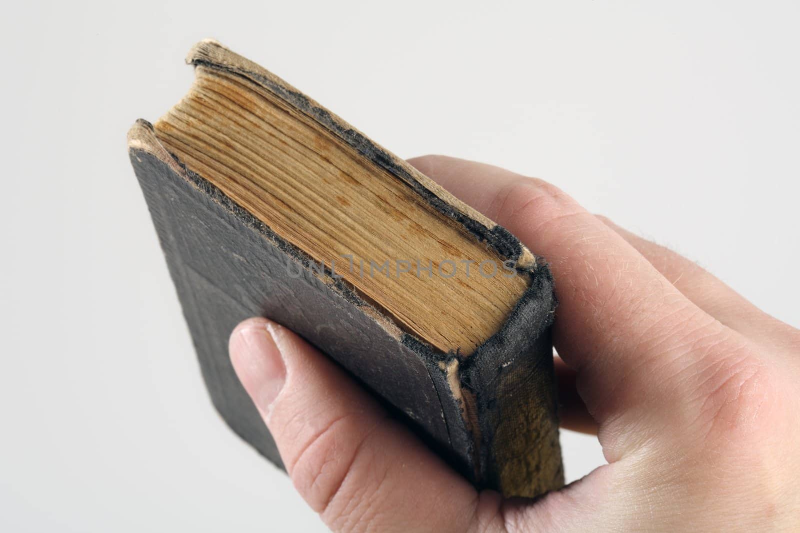 A hand grabbing an old small book