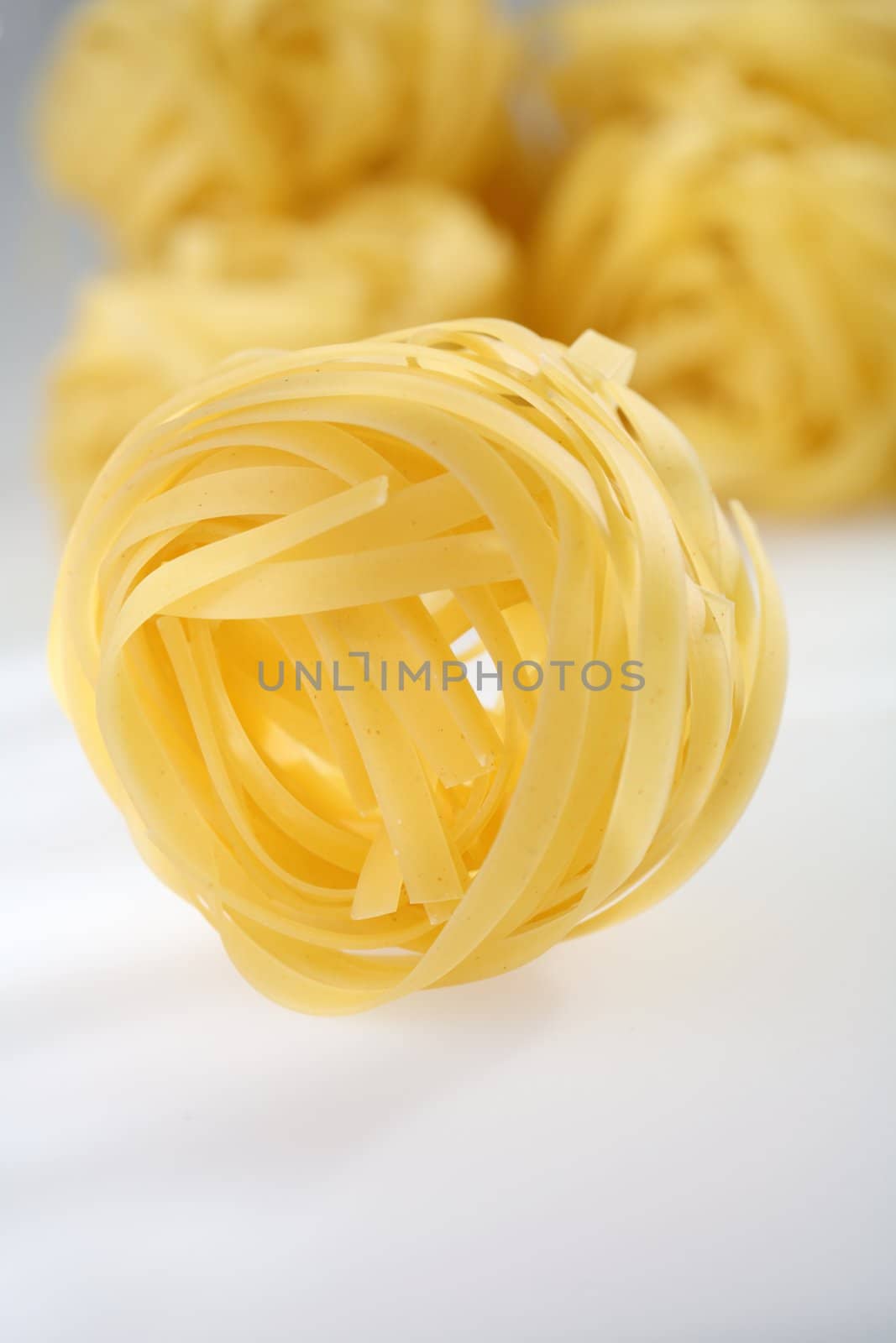 Uncooked raw pasta tagliatelle. Short depth-of-field