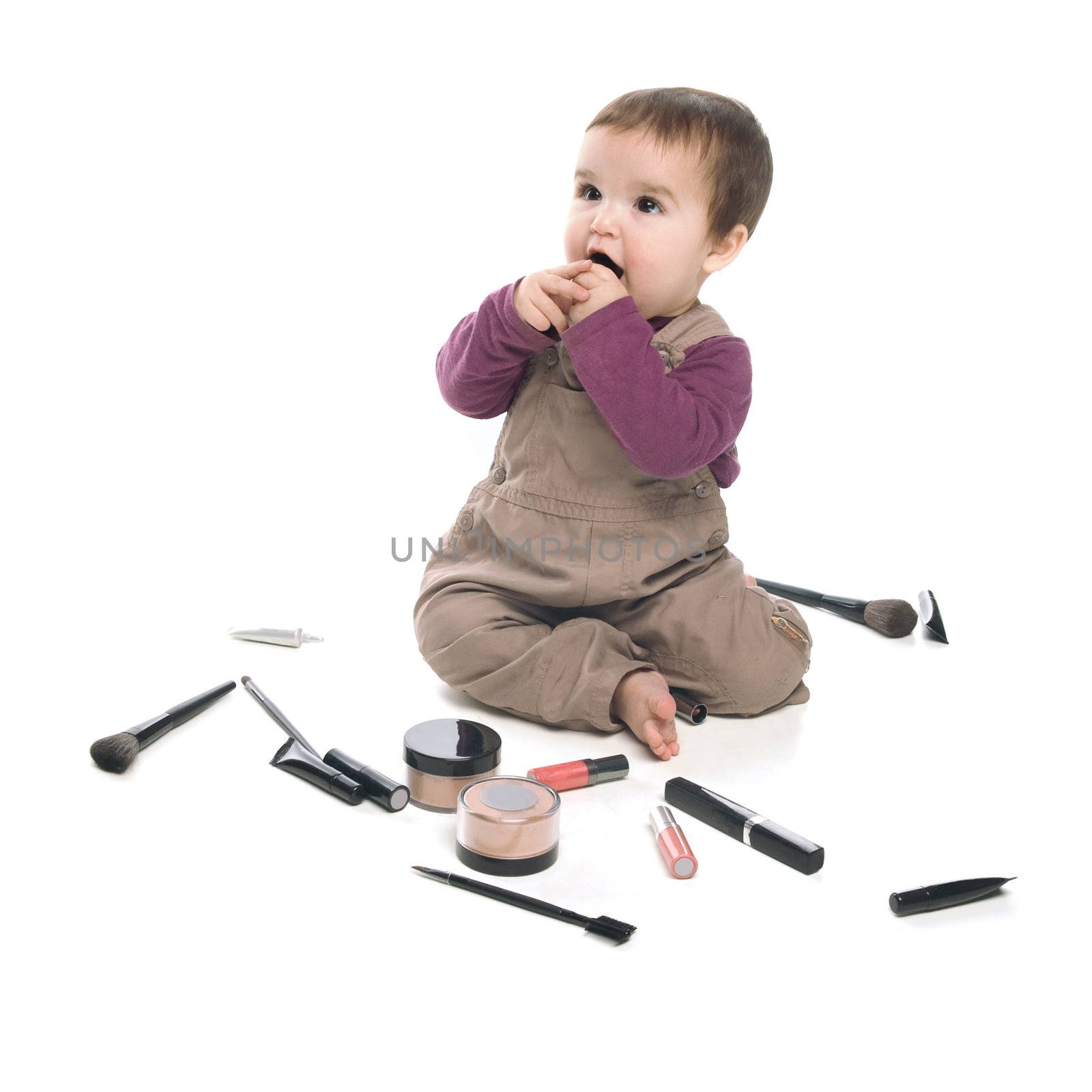 Baby girl playing with cosmetics, white background