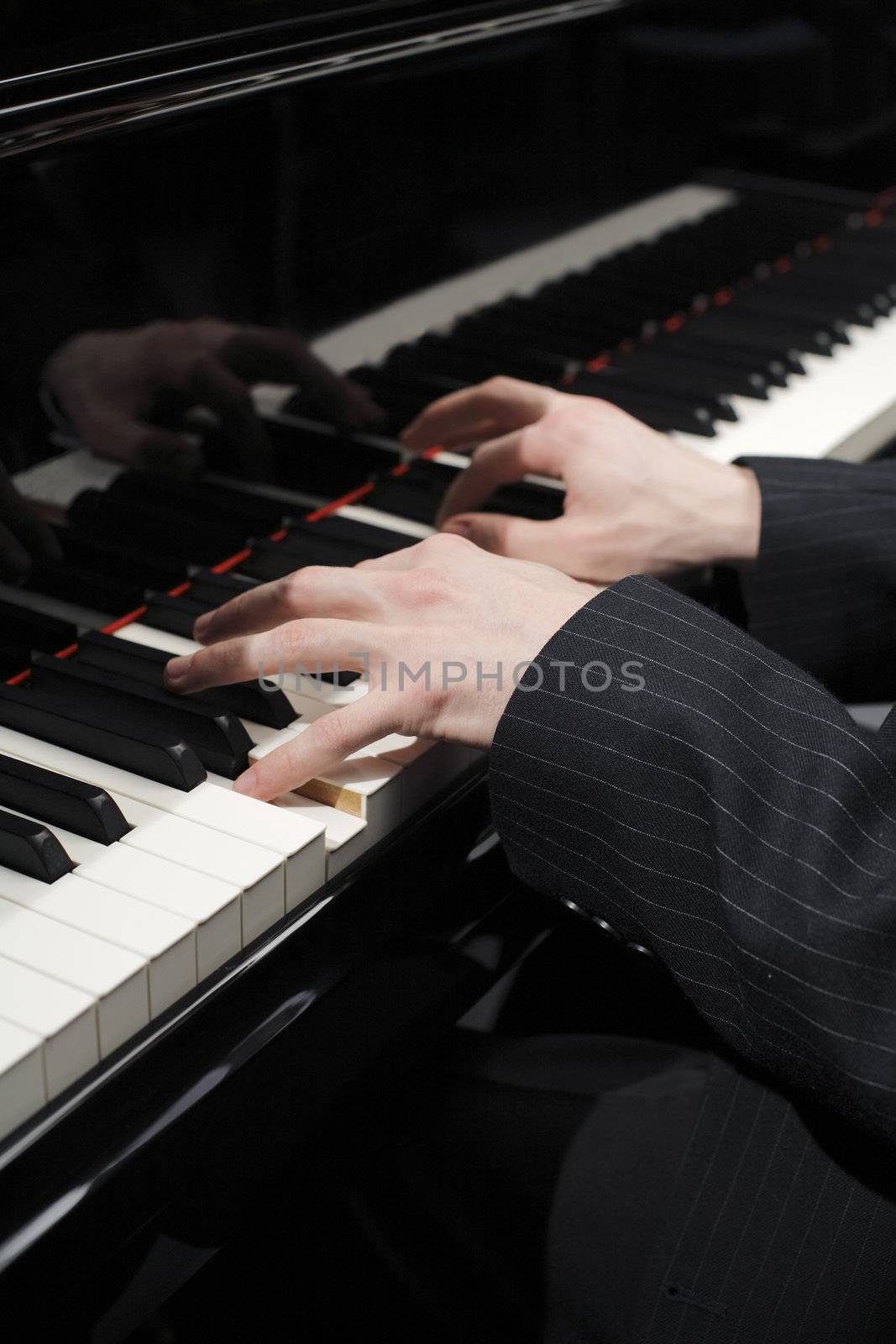 Hands of pianist playing on keys