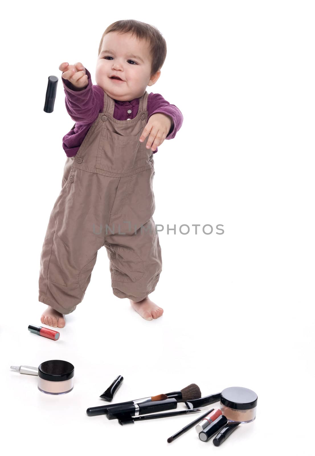 Baby girl playing with cosmetics, white background