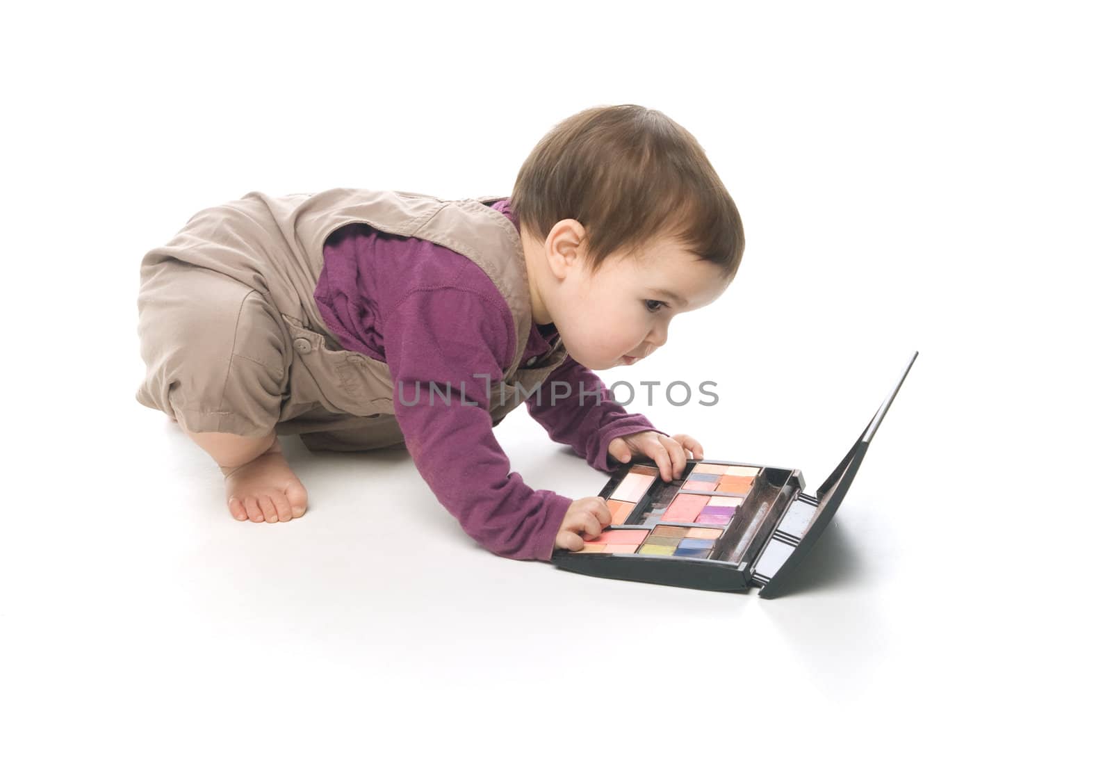 Baby girl playing with a cosmetic box