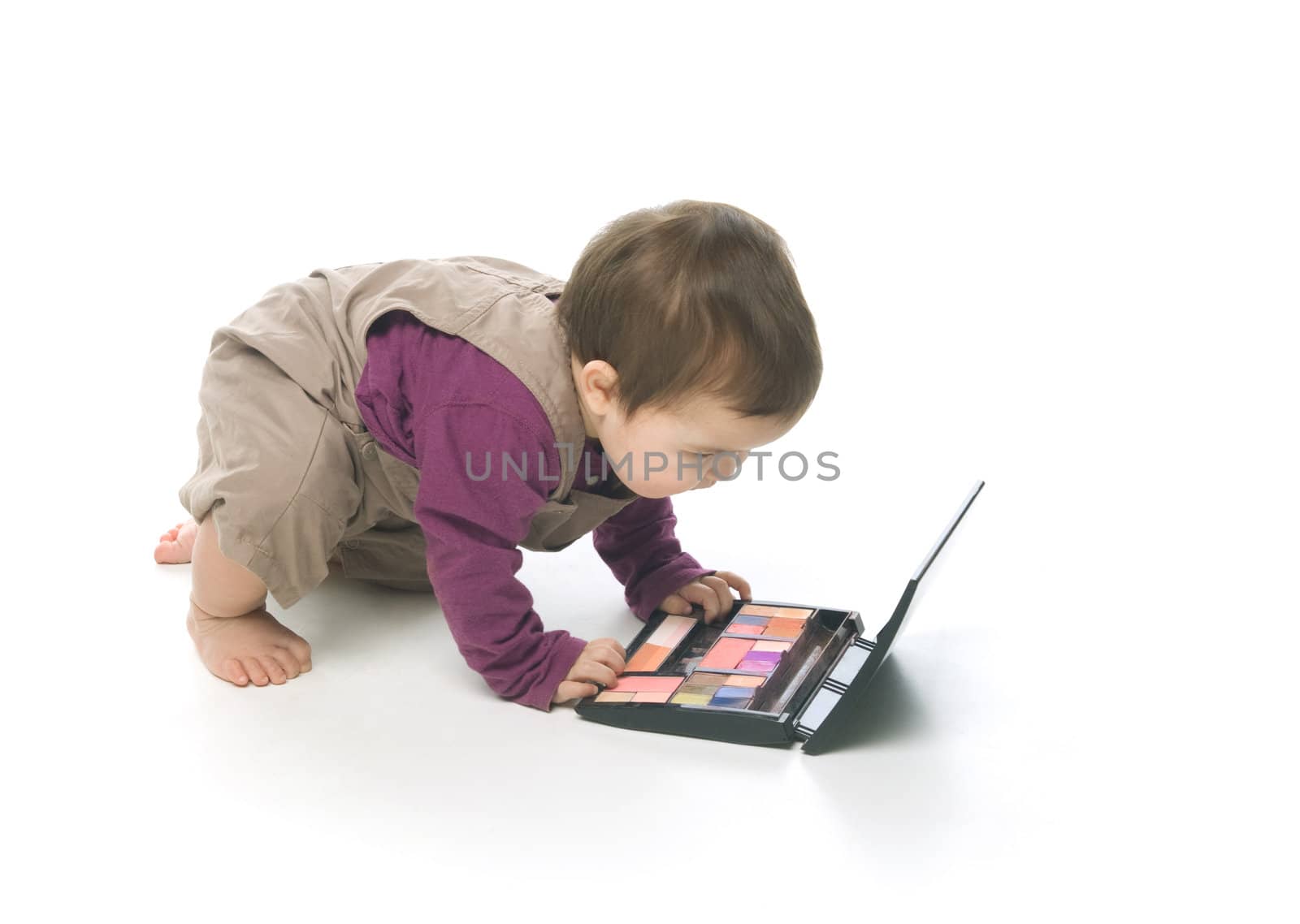 Baby girl playing with a cosmetic box