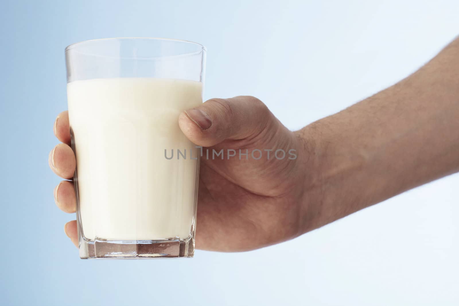 A Hand holding a glass of milk