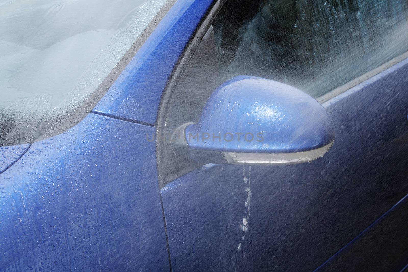 Spraying water on a blue car