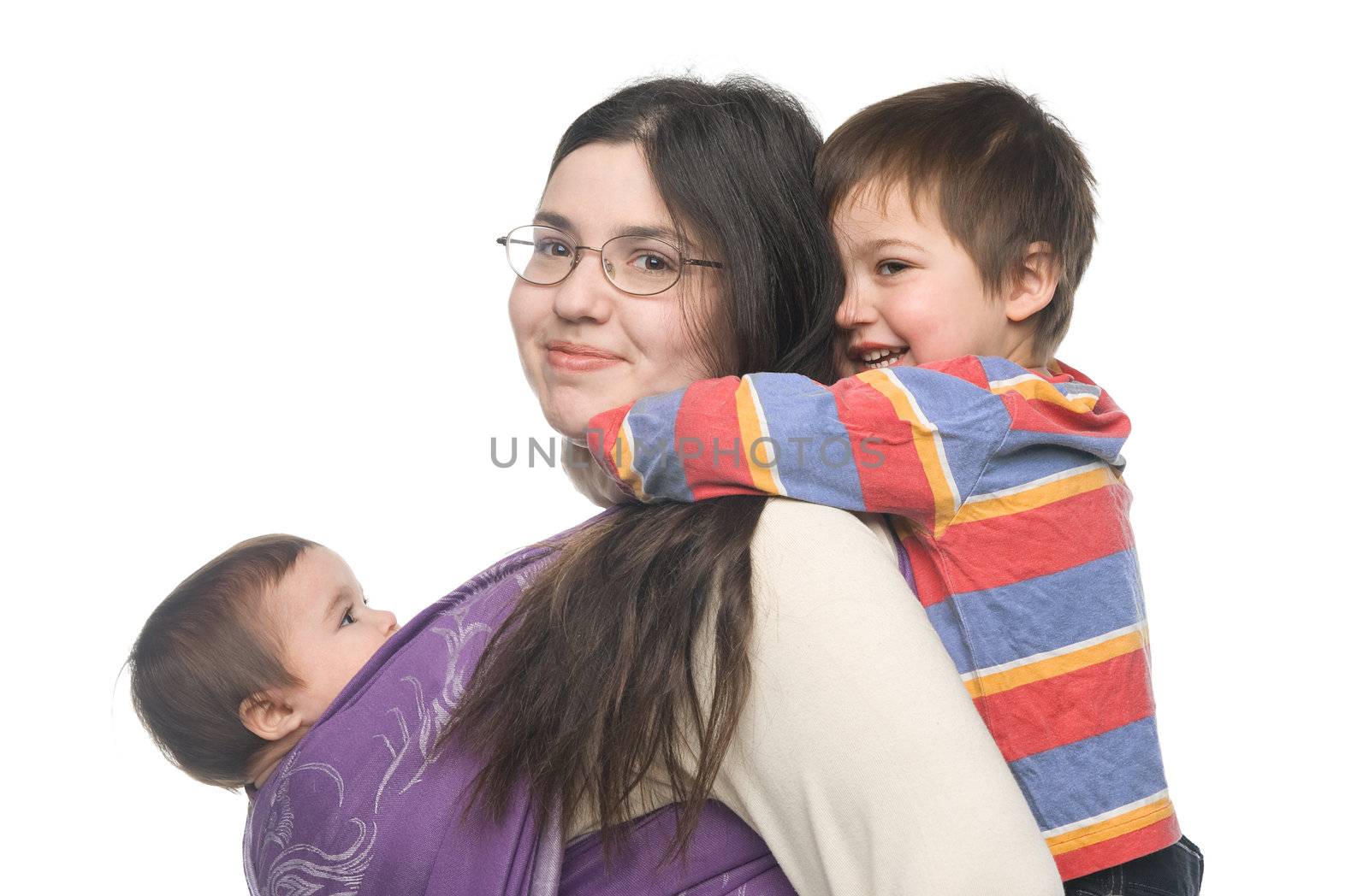 Woman carrying her little daughter in a sling. Her son hugging her from behind