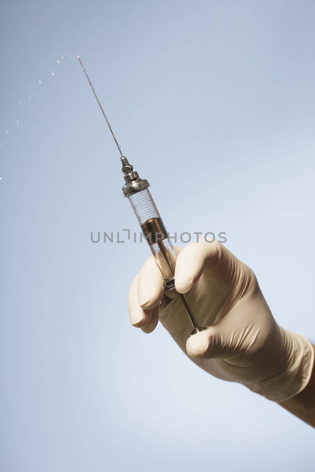 Hand holding an old-fashioned glass syringe