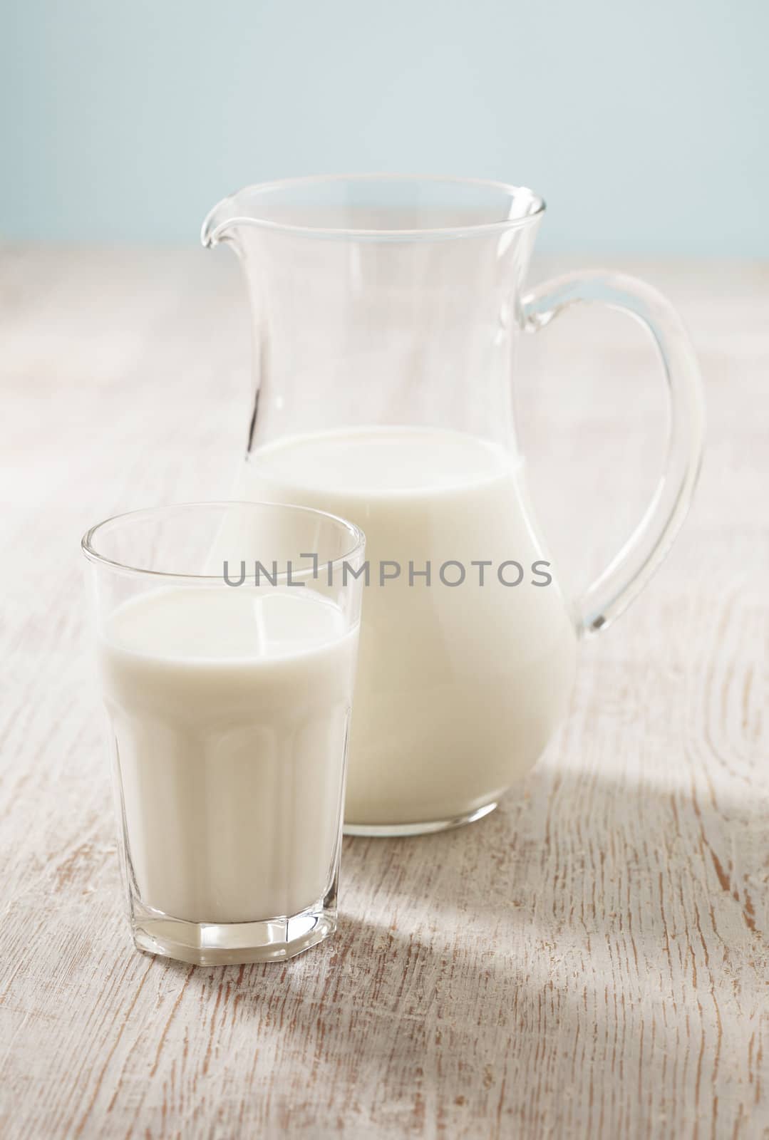 Milk in a pitcher and in a glass. Short depth of field: sharpness is in the glass