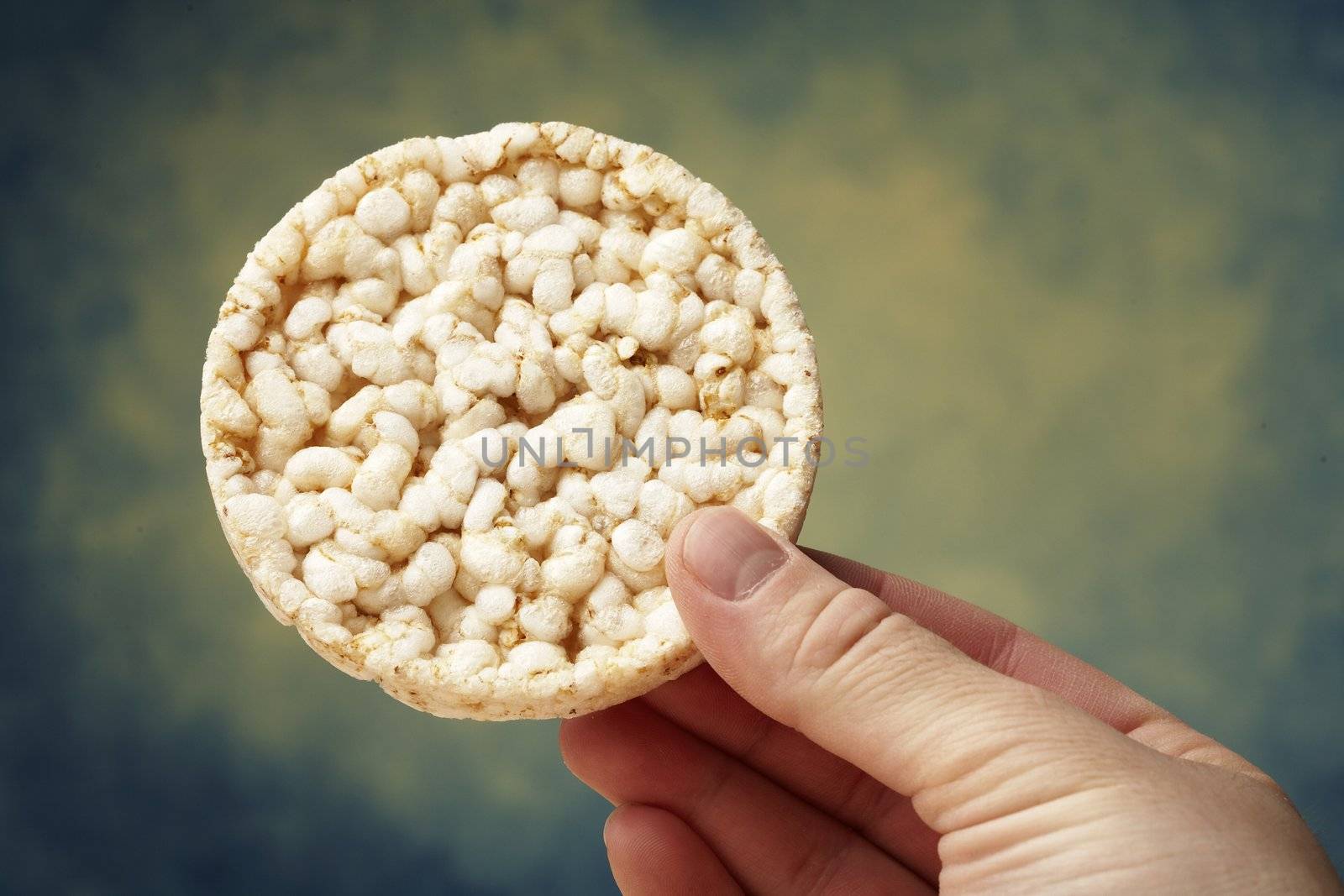 A hand holding a rice cake