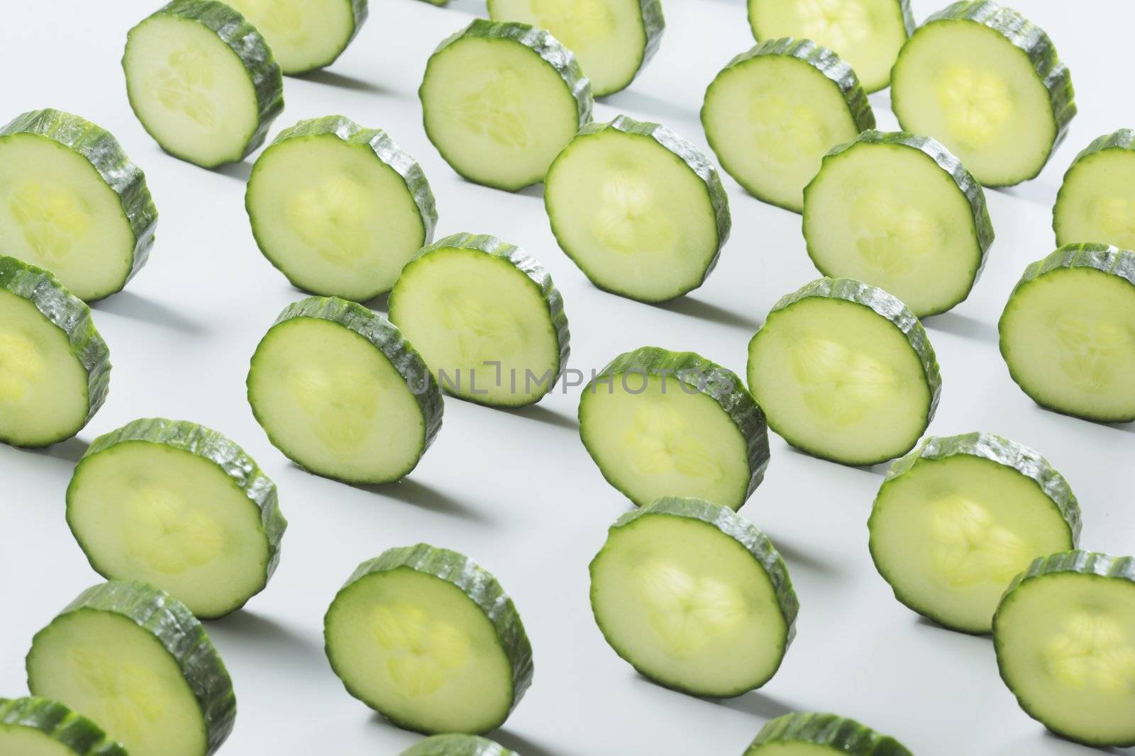Sliced cucumber on light grey background