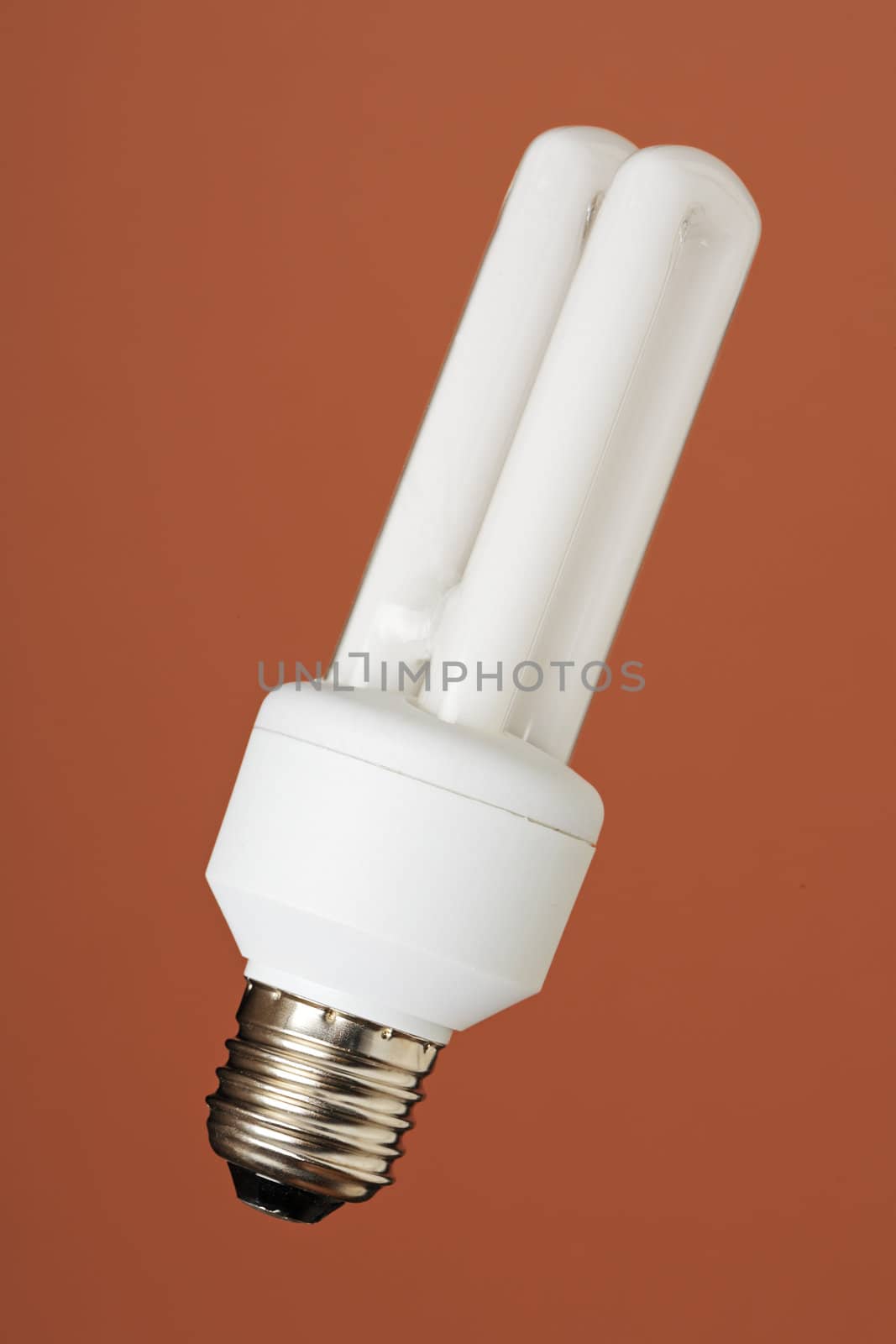 Energy saving compact fluorescent bulb on brown background