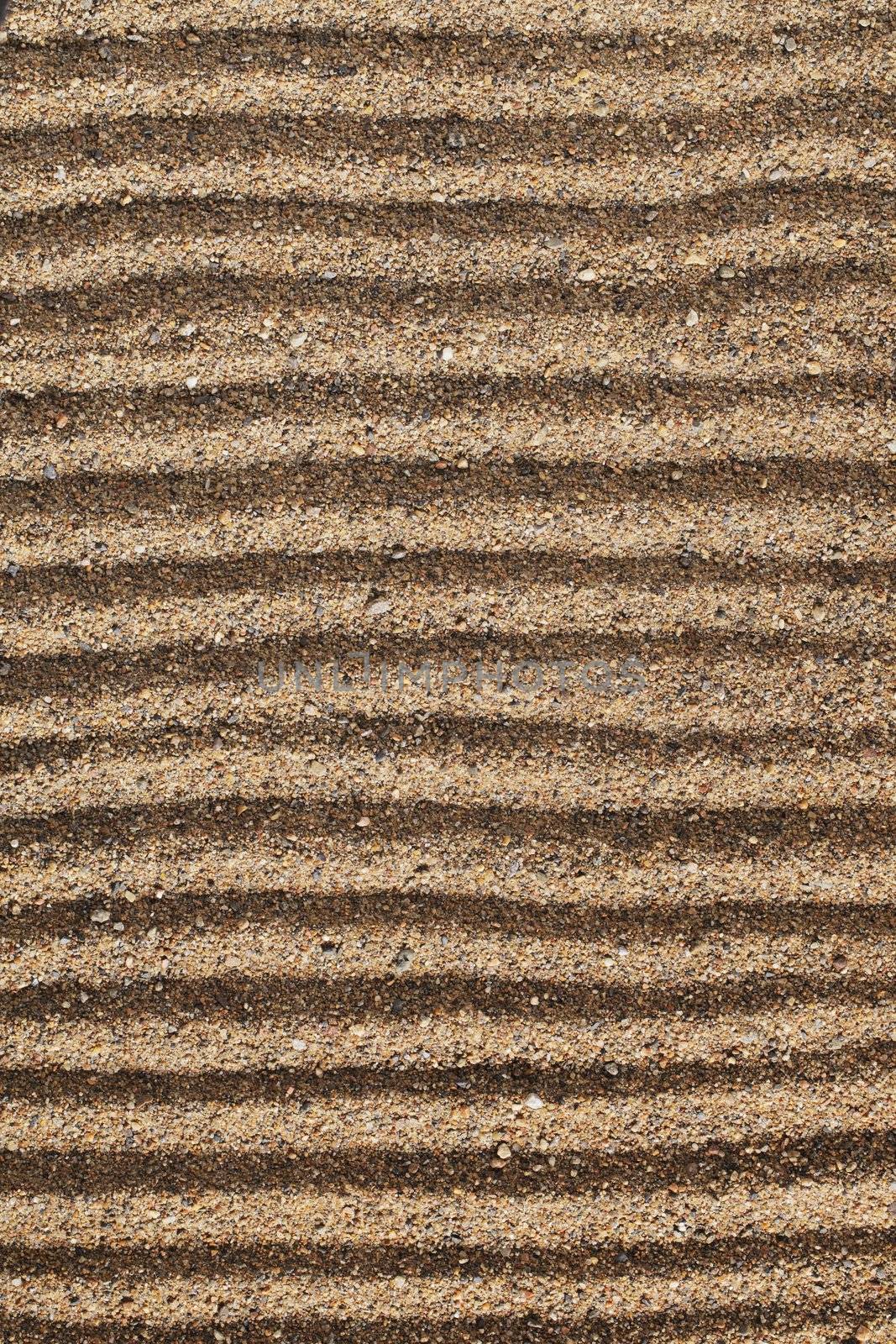 Horizontal lines drawn into coarse sea sand.