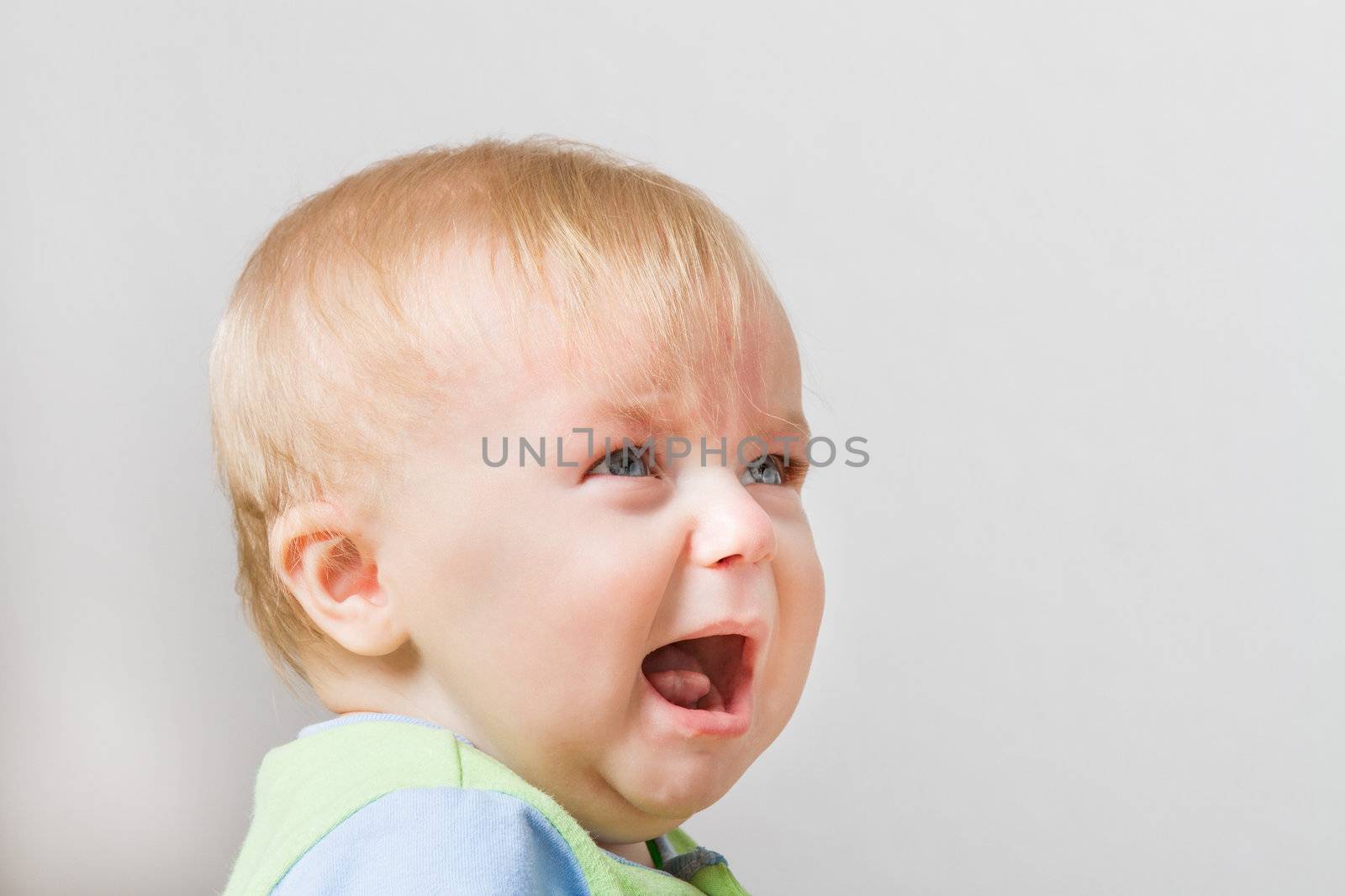 Crying boy around 7 months of age. Some space for your own text on the side