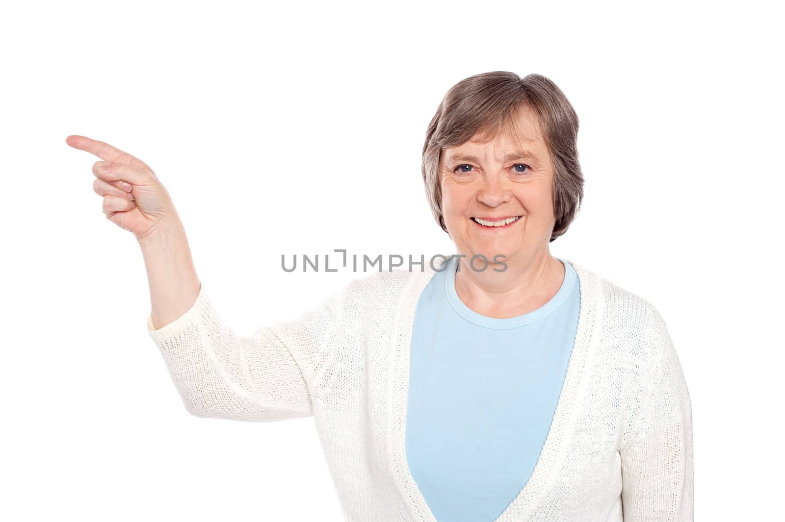 Matured casual lady pointing at copy space over white background