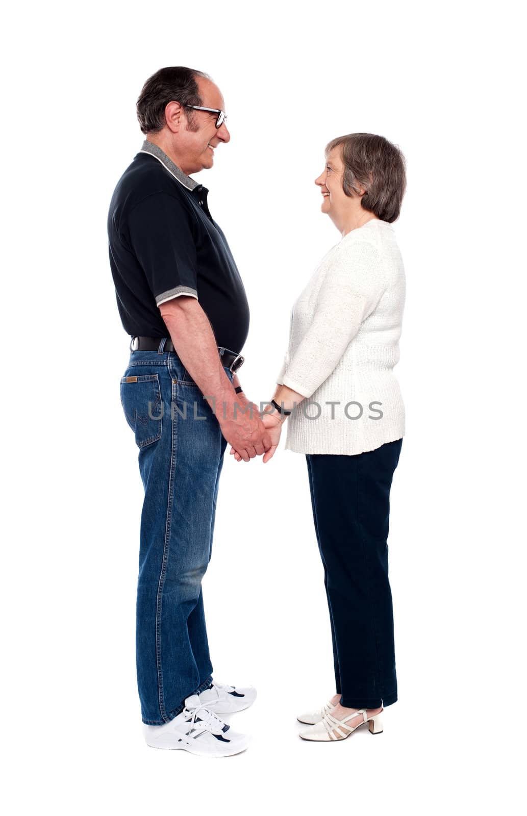 Aged couple looking at each other and holding hands. All on white background