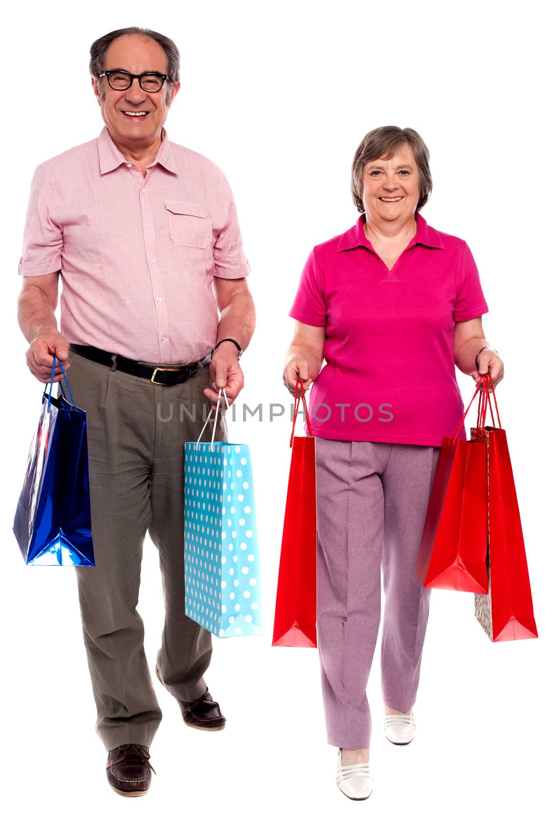 Husband and wife holding shopping bags and walking towards camera