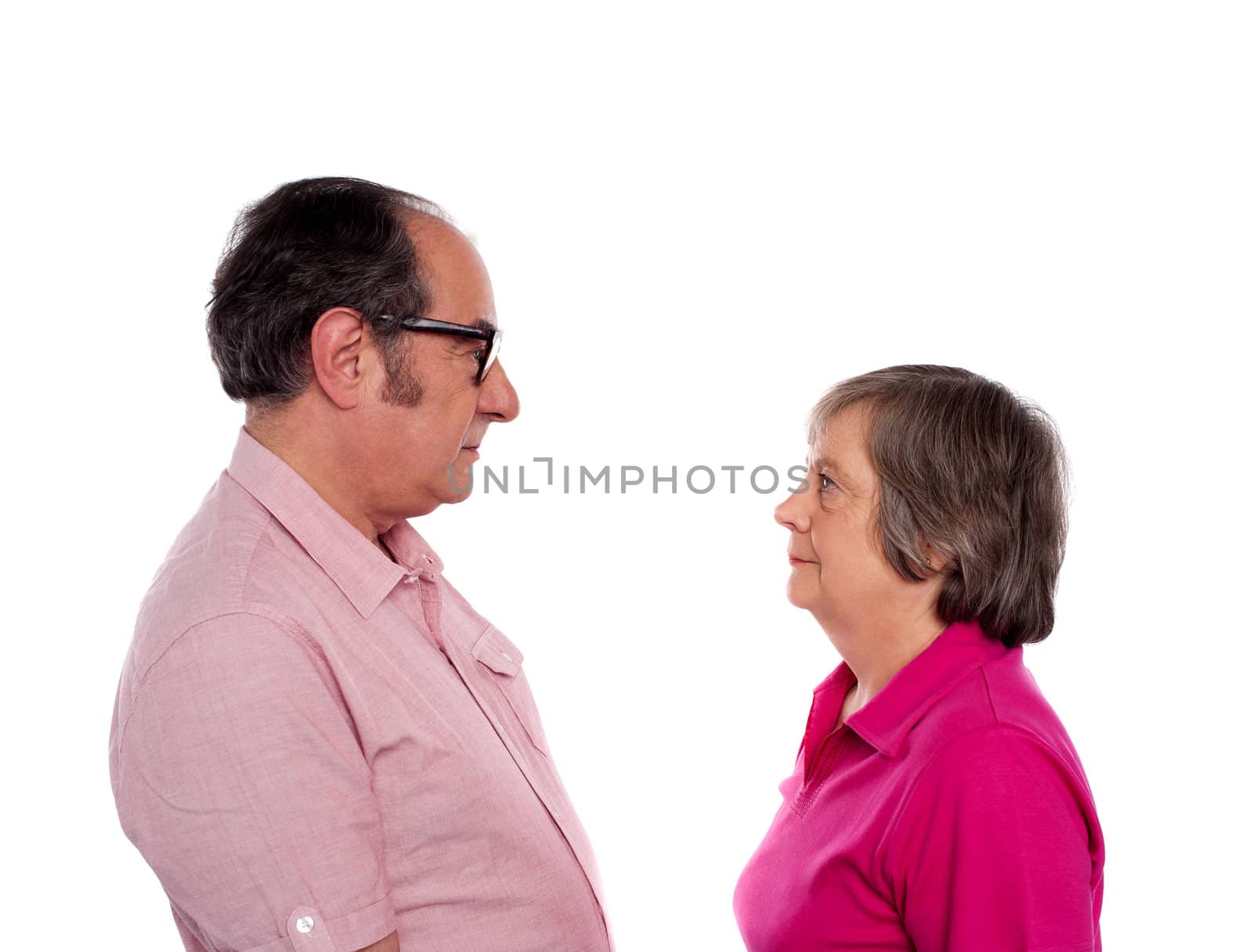 Beautiful aged couple looking into each others eyes isolated over white