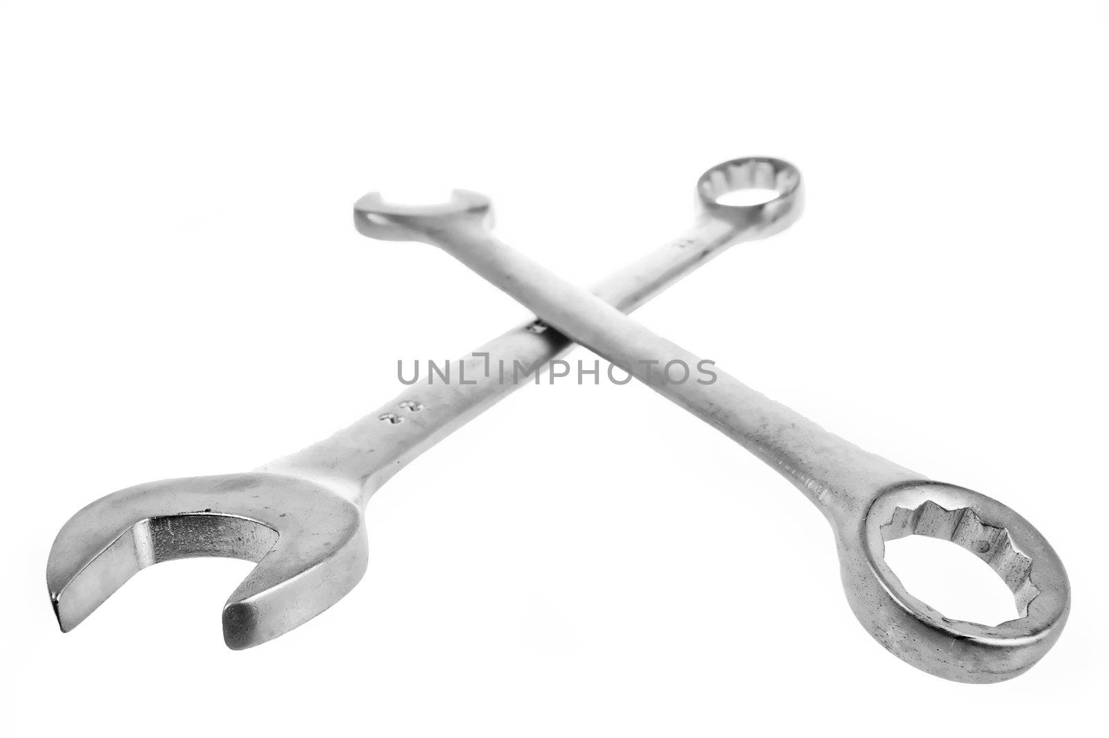 Two crossed wrenches on a white lie