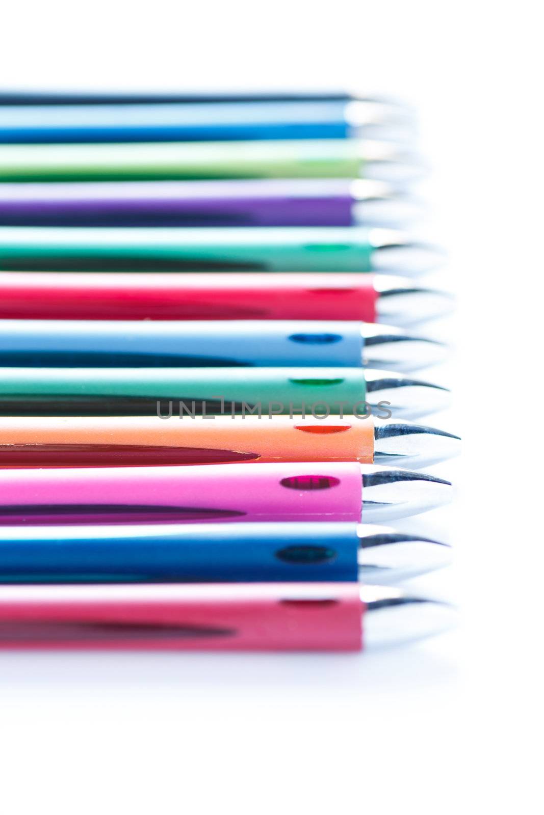 Line of many colored pens on a white background