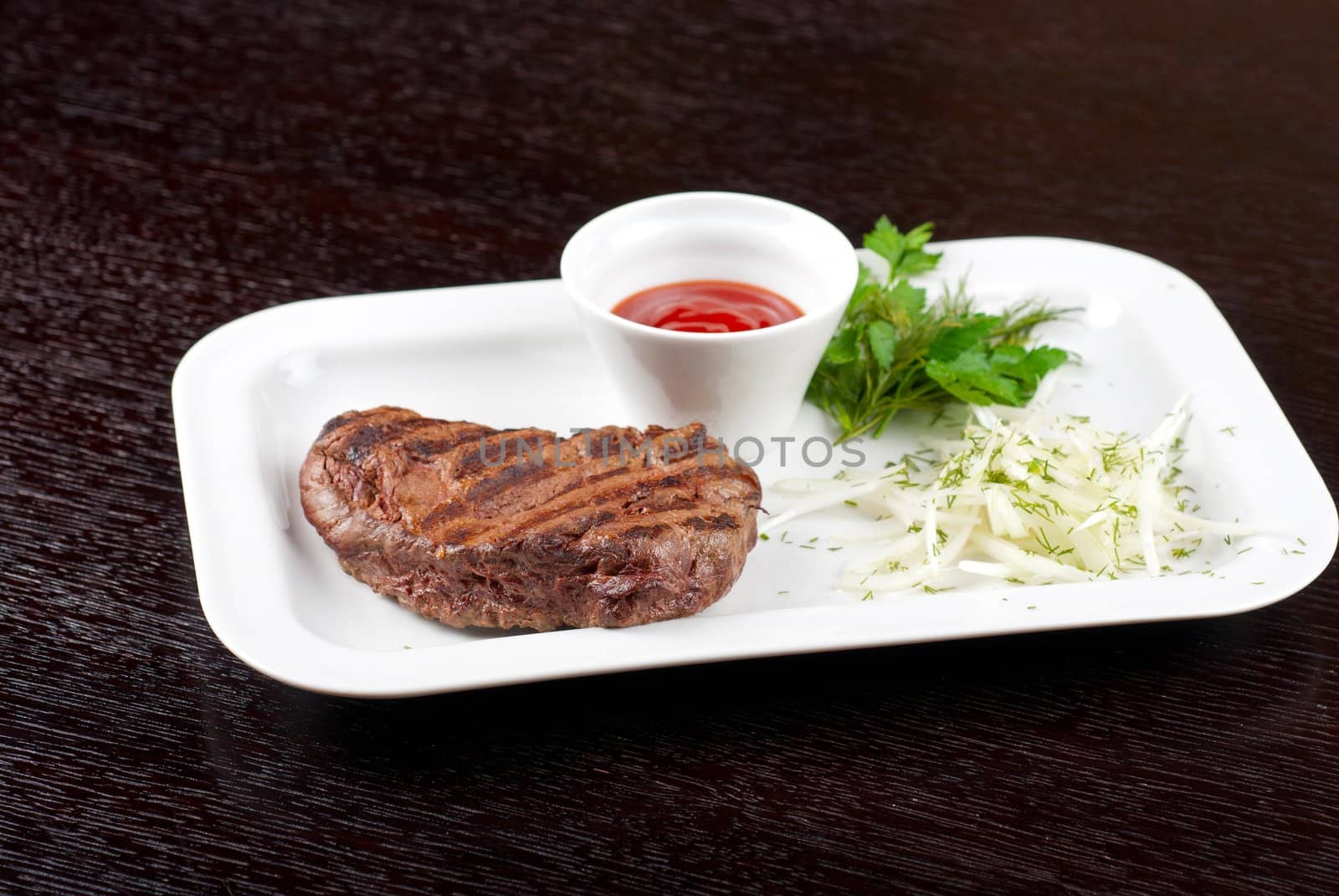 Juicy roasted beef steak with vegetables closeup at plate