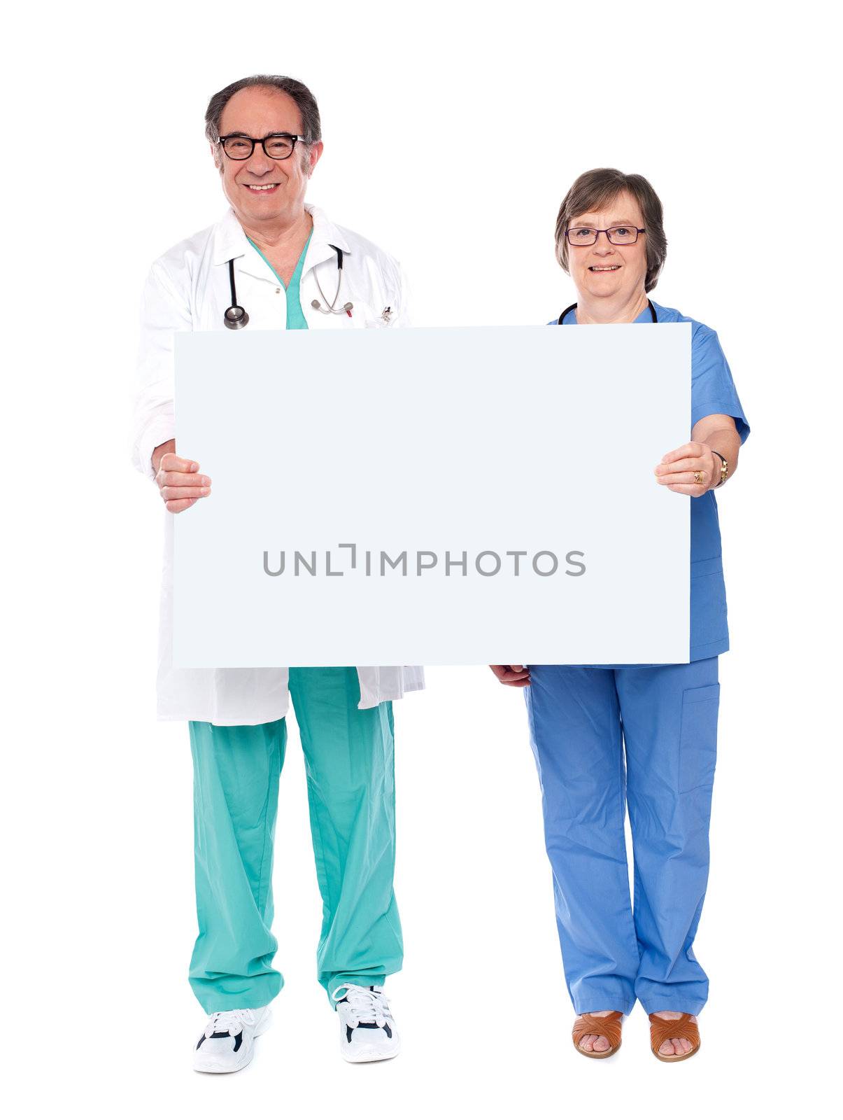 Aged doctors displaying white billboard by stockyimages