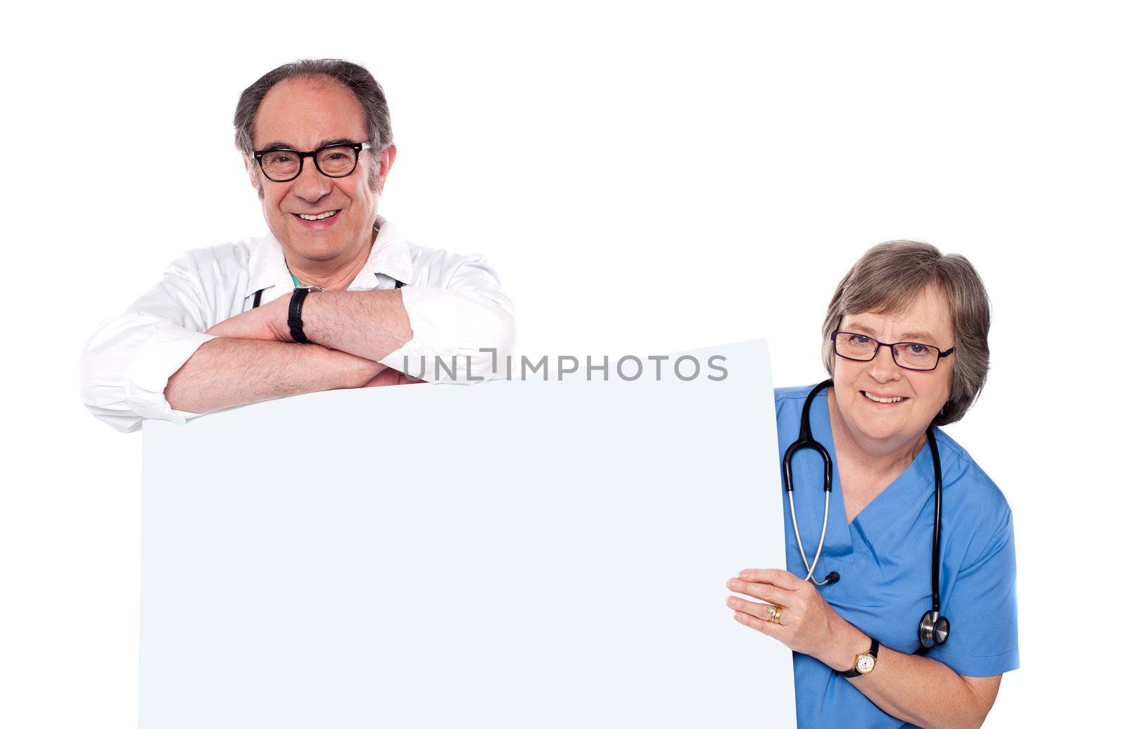 Two matured doctors holding white banner ad by stockyimages