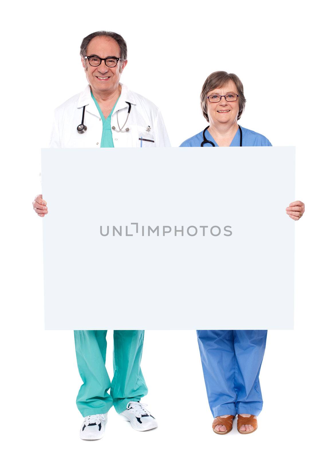 Medical professionals showing blank billboard by stockyimages