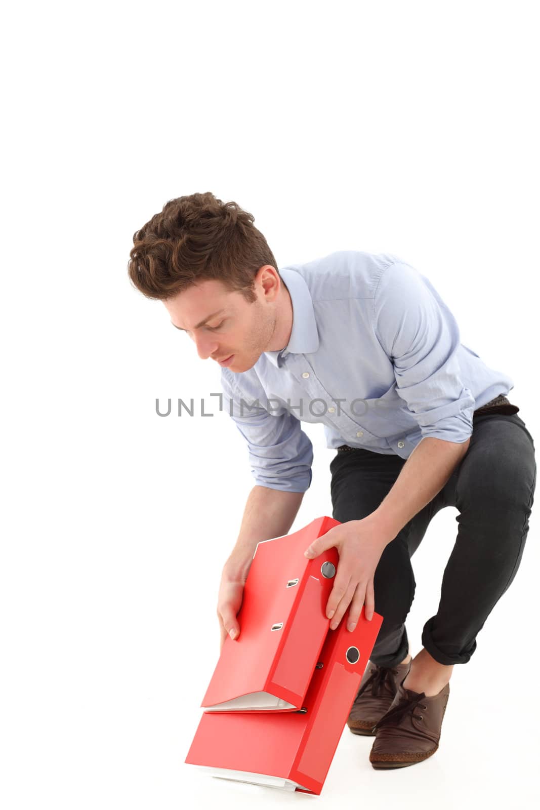 Young man in office with falling folders