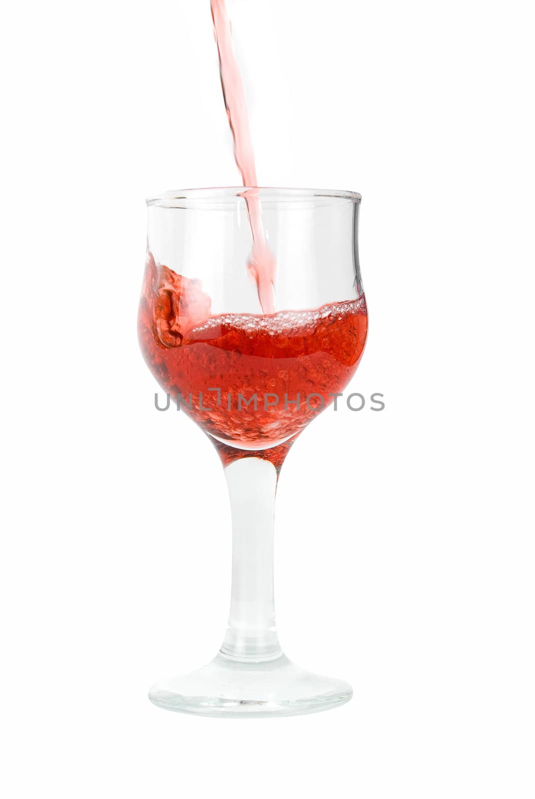 Red wine being poured into a wine glass isolated on white