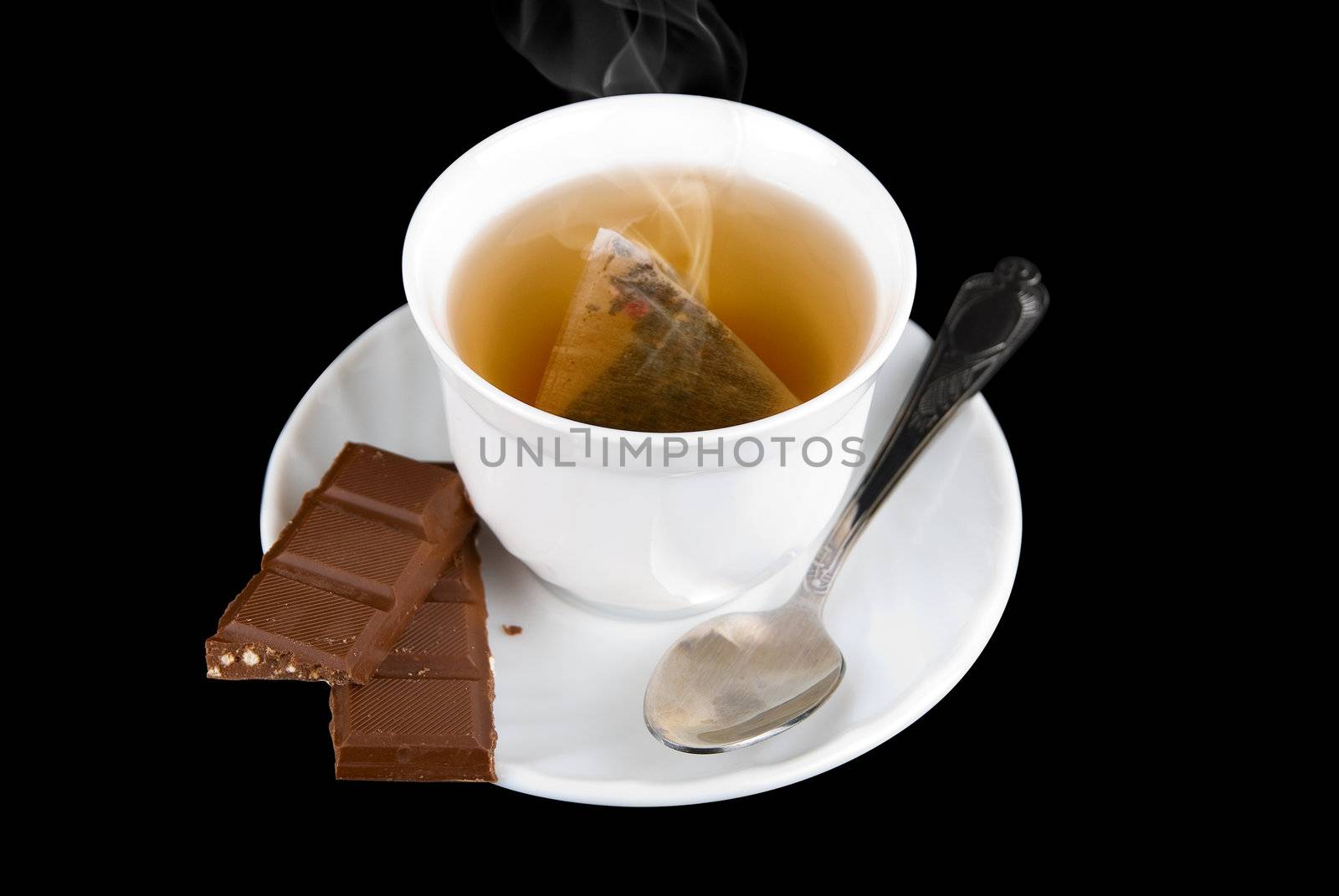 a sweets  chocolate with cup of the tea on black