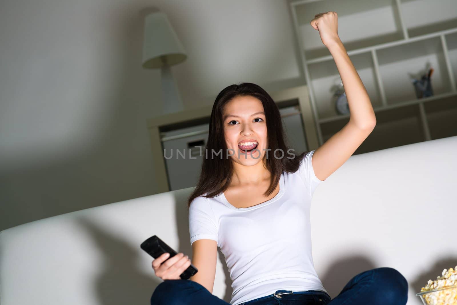 Asian young girl with excitement at night watching TV in the living room