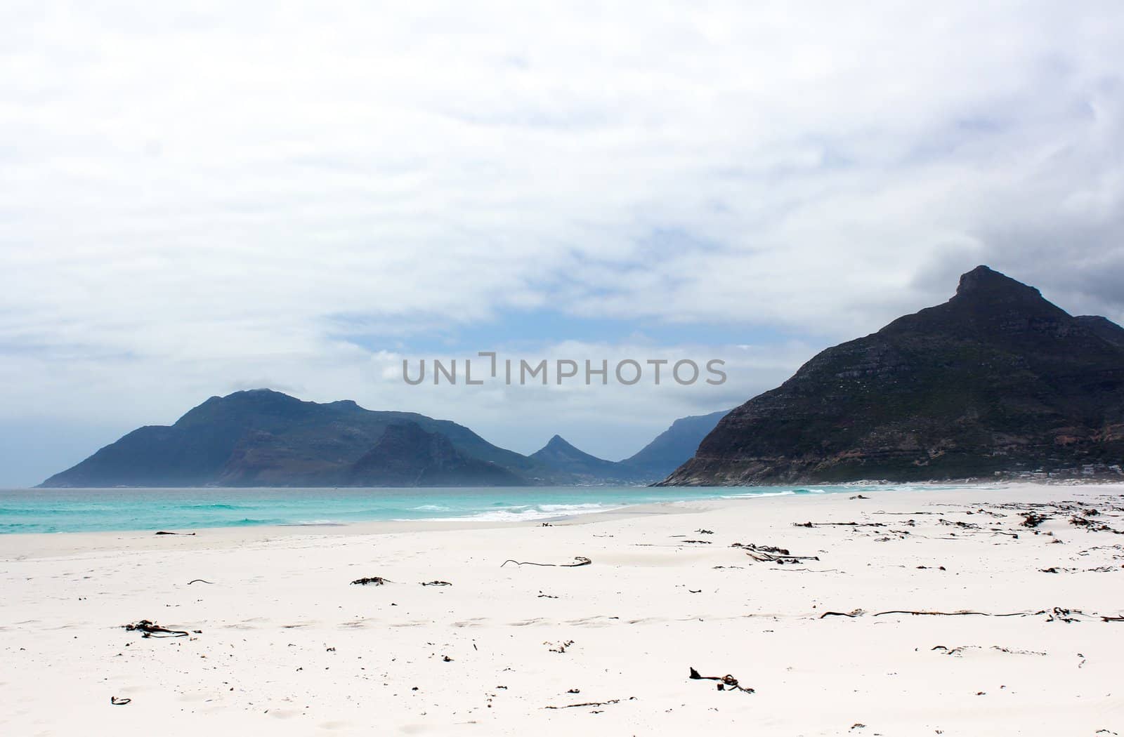 Beach of Kommetjie with an upcoming storm in the background and blue water