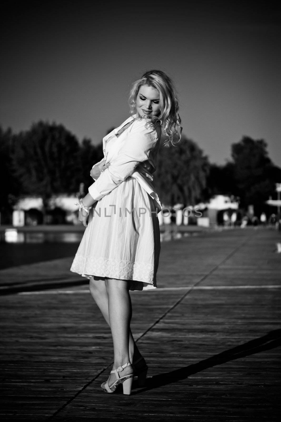 Black & White Photo of a Model standing on a wooden pier by dwaschnig_photo