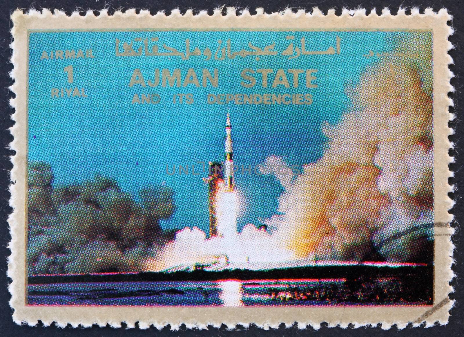 AJMAN - CIRCA 1973: a stamp printed in the Ajman shows Saturn V Rocket Launching, Moon-landing, Apollo 11, circa 1973