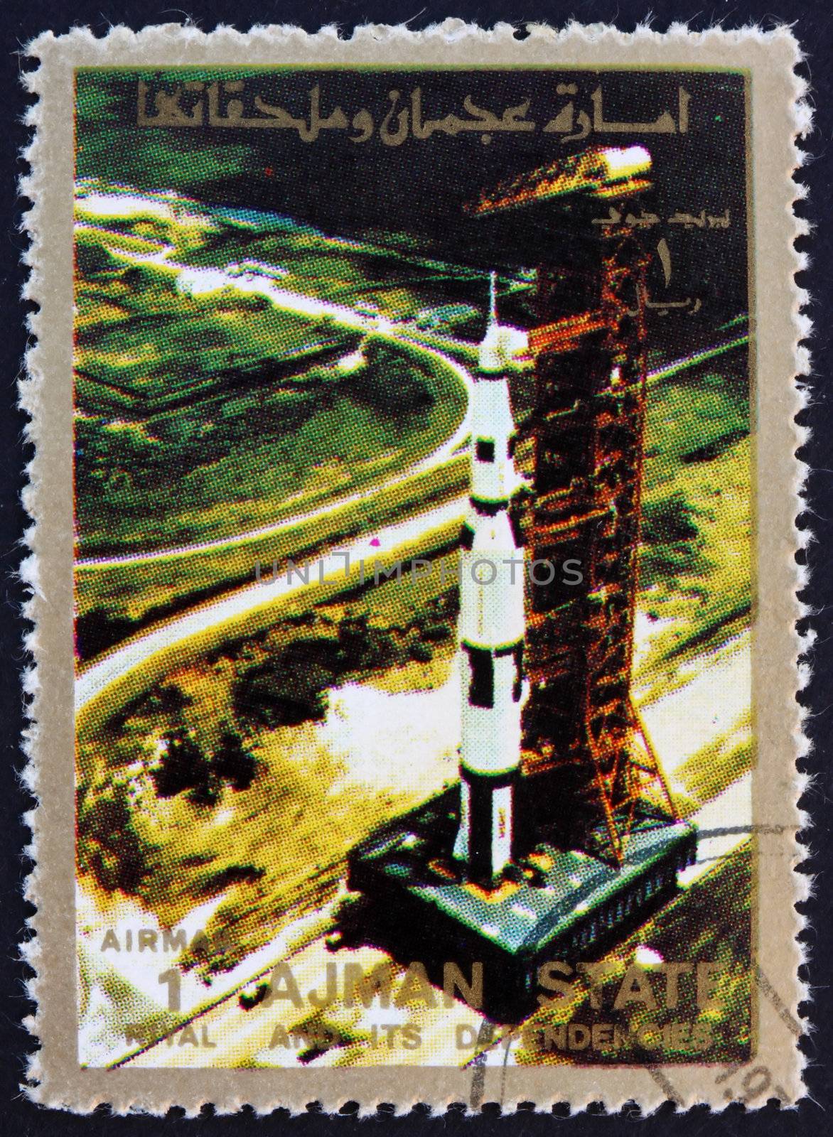 AJMAN - CIRCA 1973: a stamp printed in the Ajman shows Roll out of Saturn 5 on launch pad, Moon-landing, Apollo 11, circa 1973