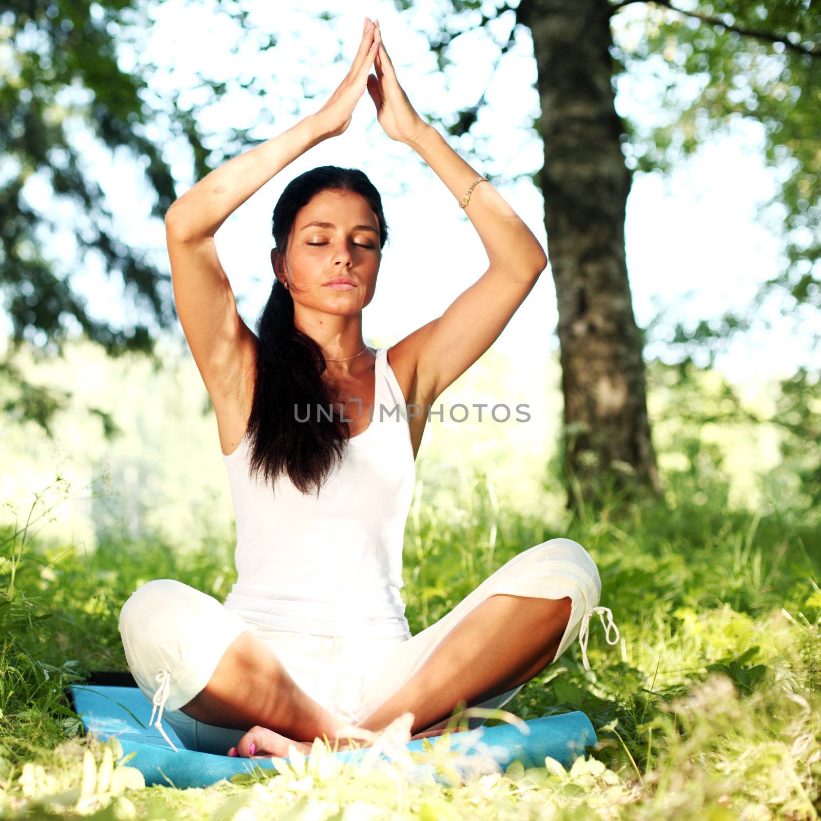  yoga woman on green grass in lotus pose