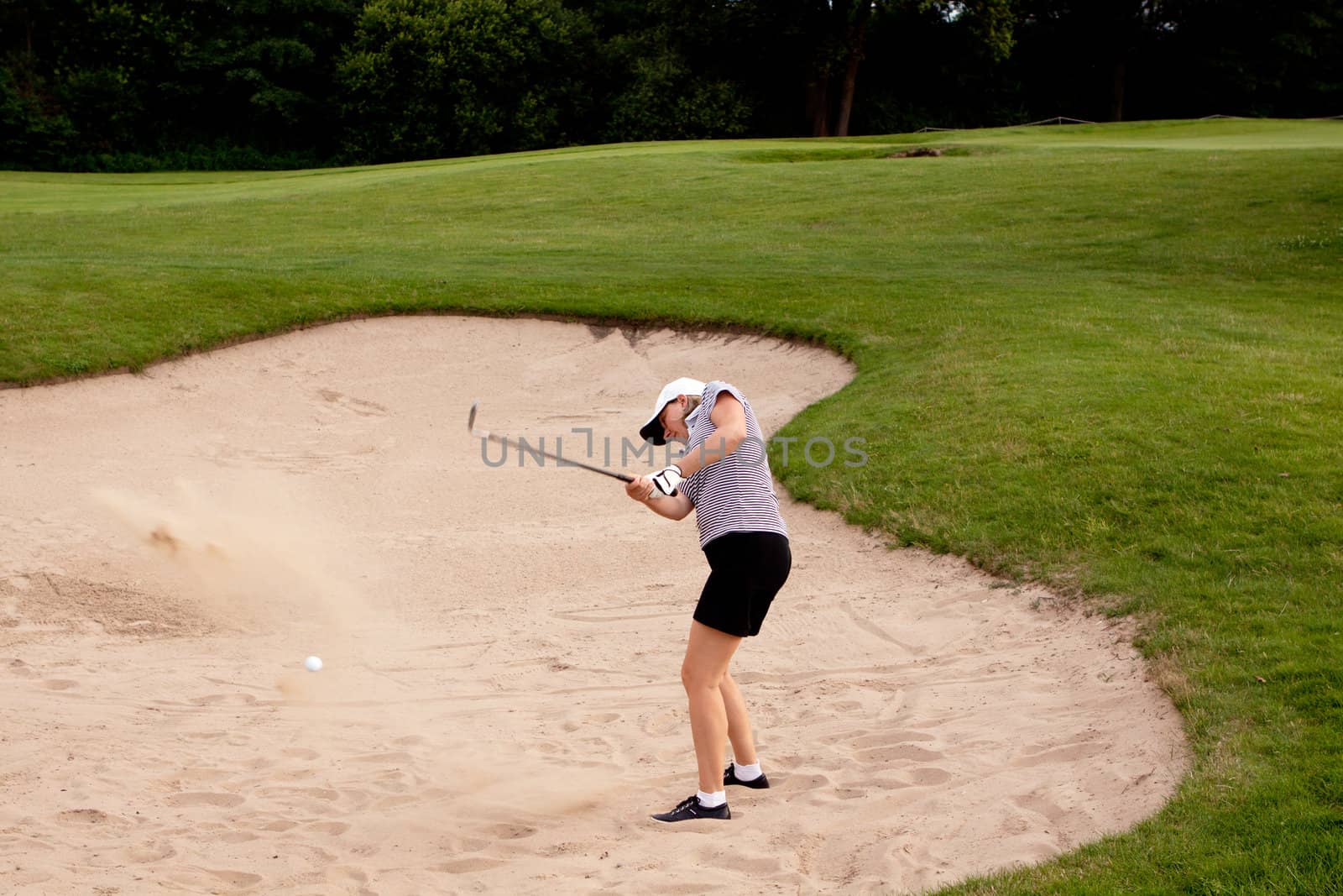 woman is playing golf on course  in summer in a golf-club