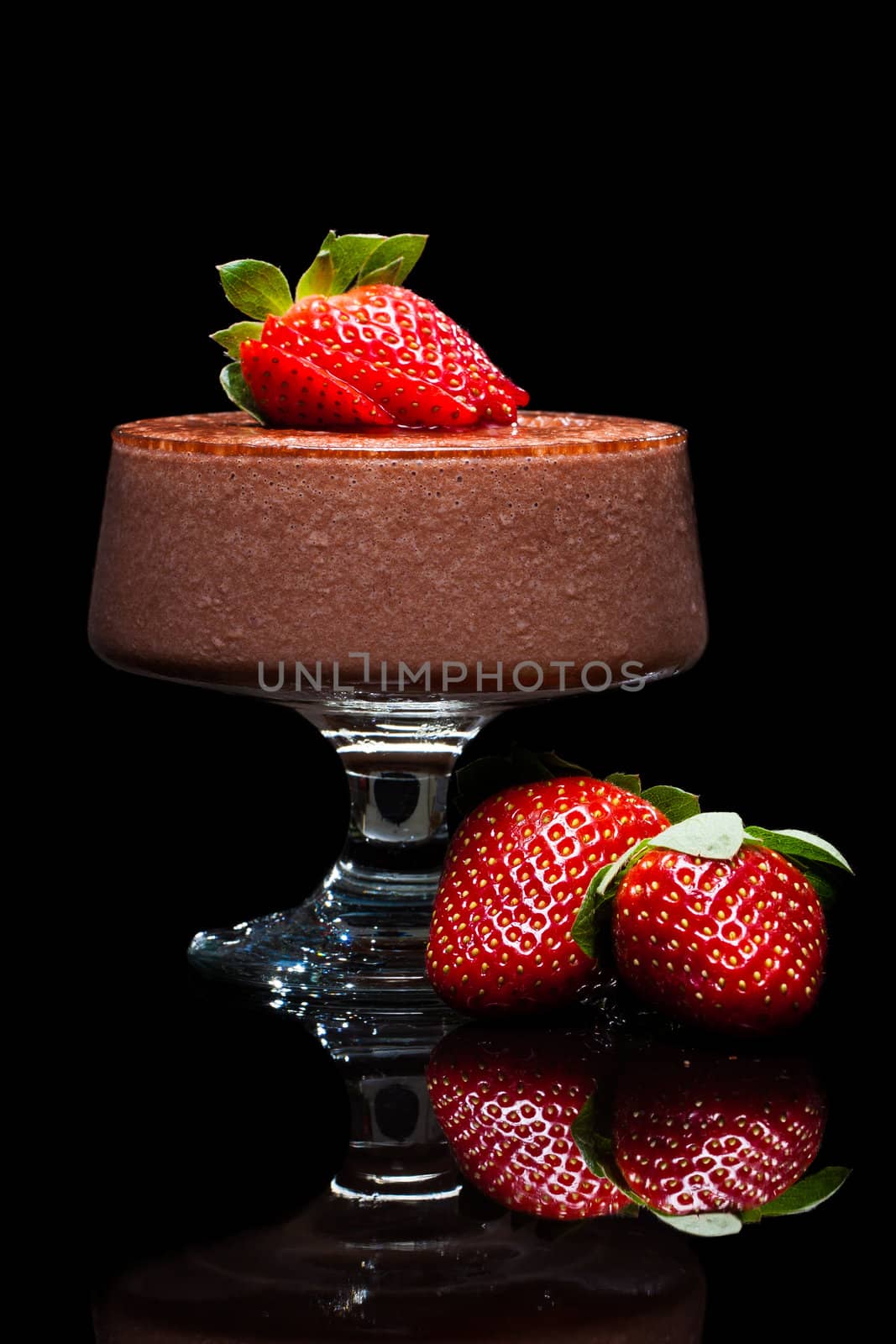Chocolate mousse dessert with delicious red strawberries. Isolated on black.