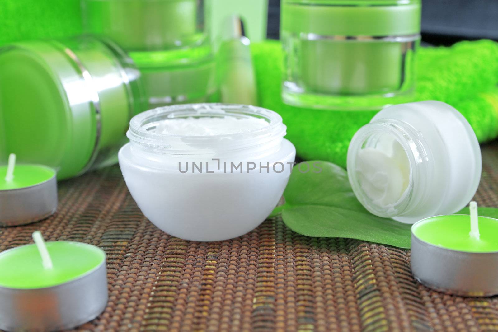 creams for body care in transparent and green containers