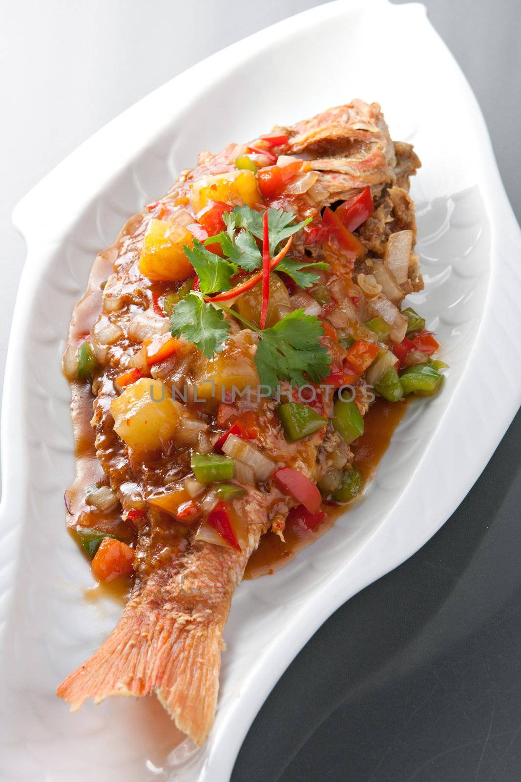 Freshly prepared Thai style whole fish red snapper dinner with tamarind sauce.