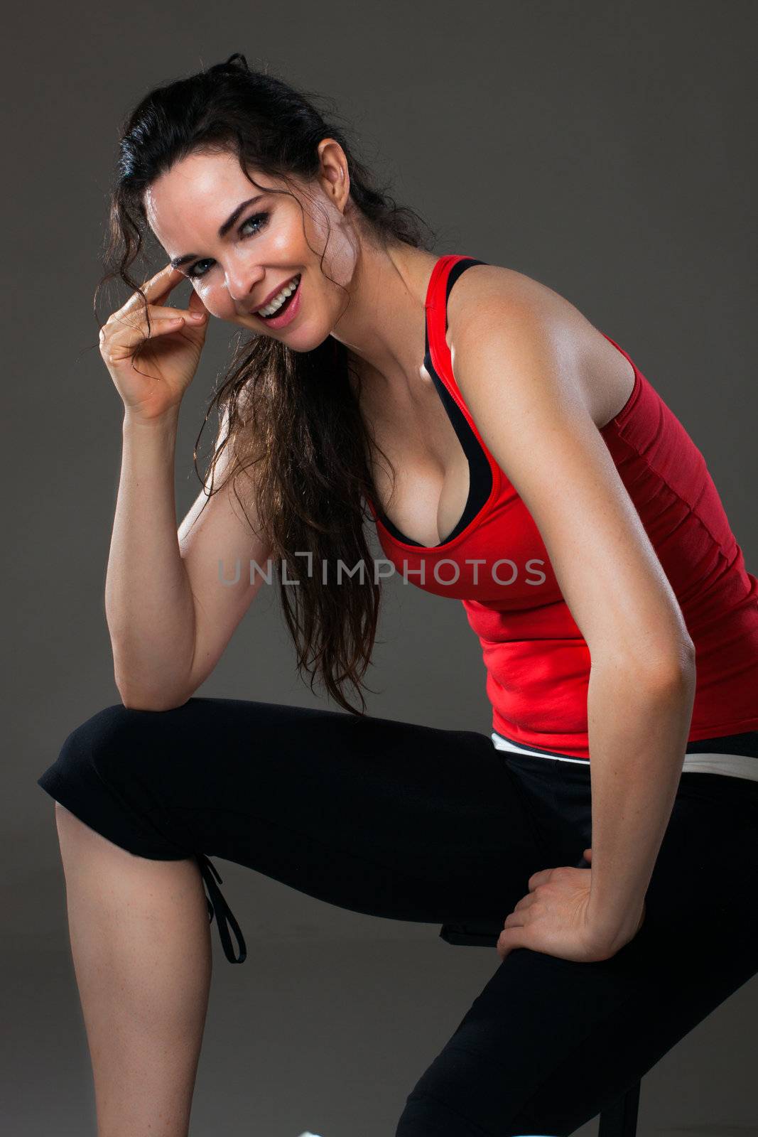 Smiling woman having a rest from exercise by Jaykayl